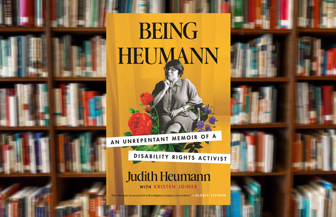 The book Being Heumann in front of a blurry book background