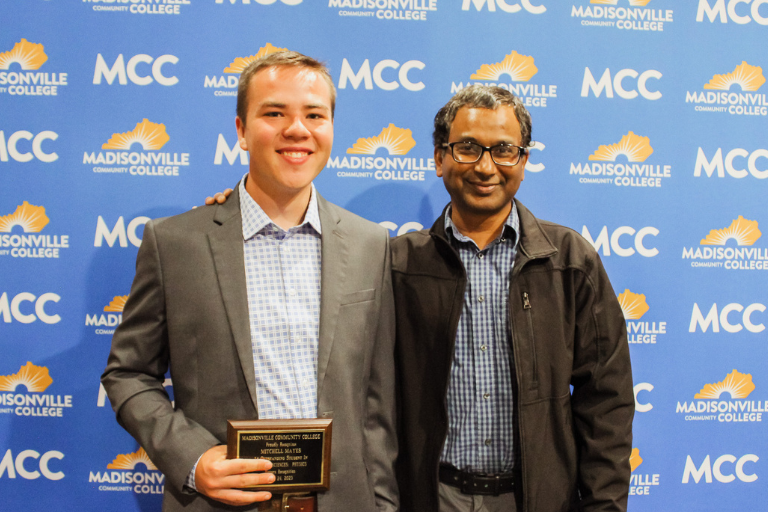 student and teaching posing with award
