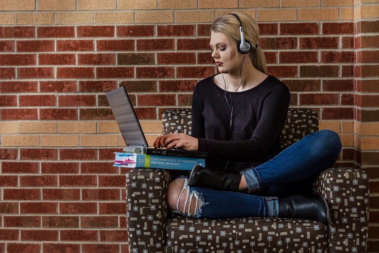 woman on headphones using a laptop
