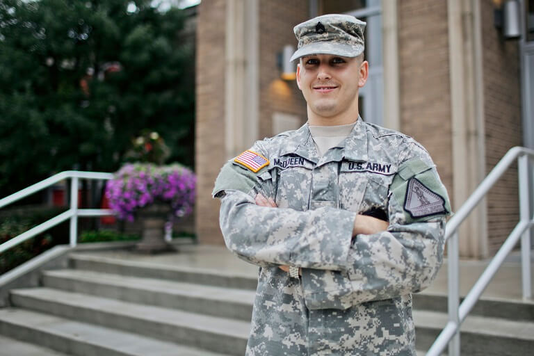 man in military uniform posing in front of building