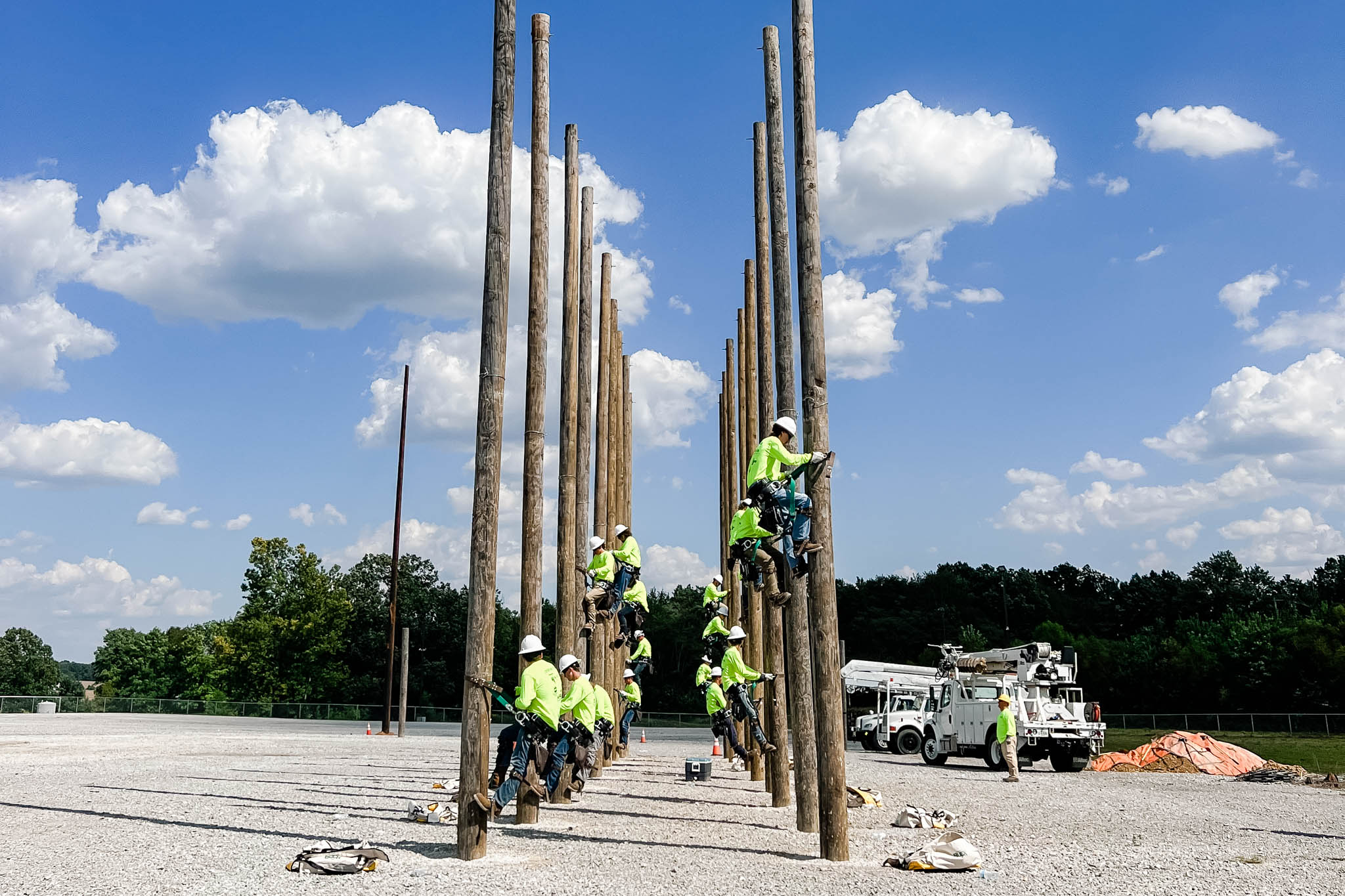 men climbing utility poles 