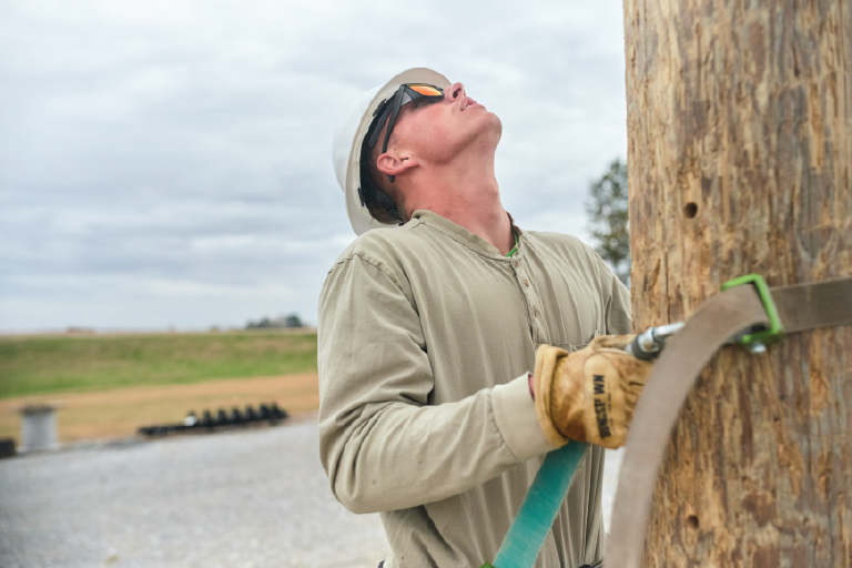 man climbing utility poles 