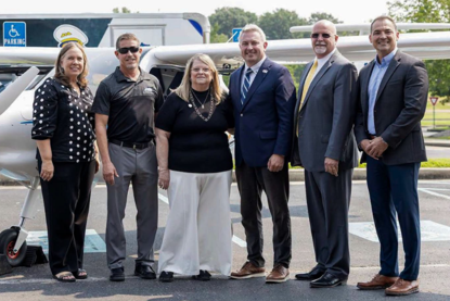Group standing in front of an electric plane